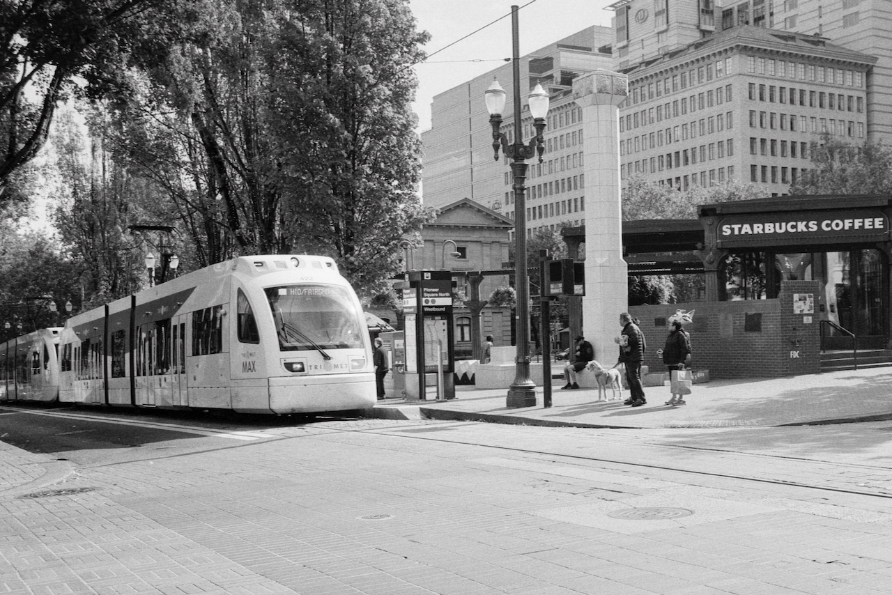 Black-and-white photo of the Portland MAX arriving at Pioneer Square in Portland, Oregon.