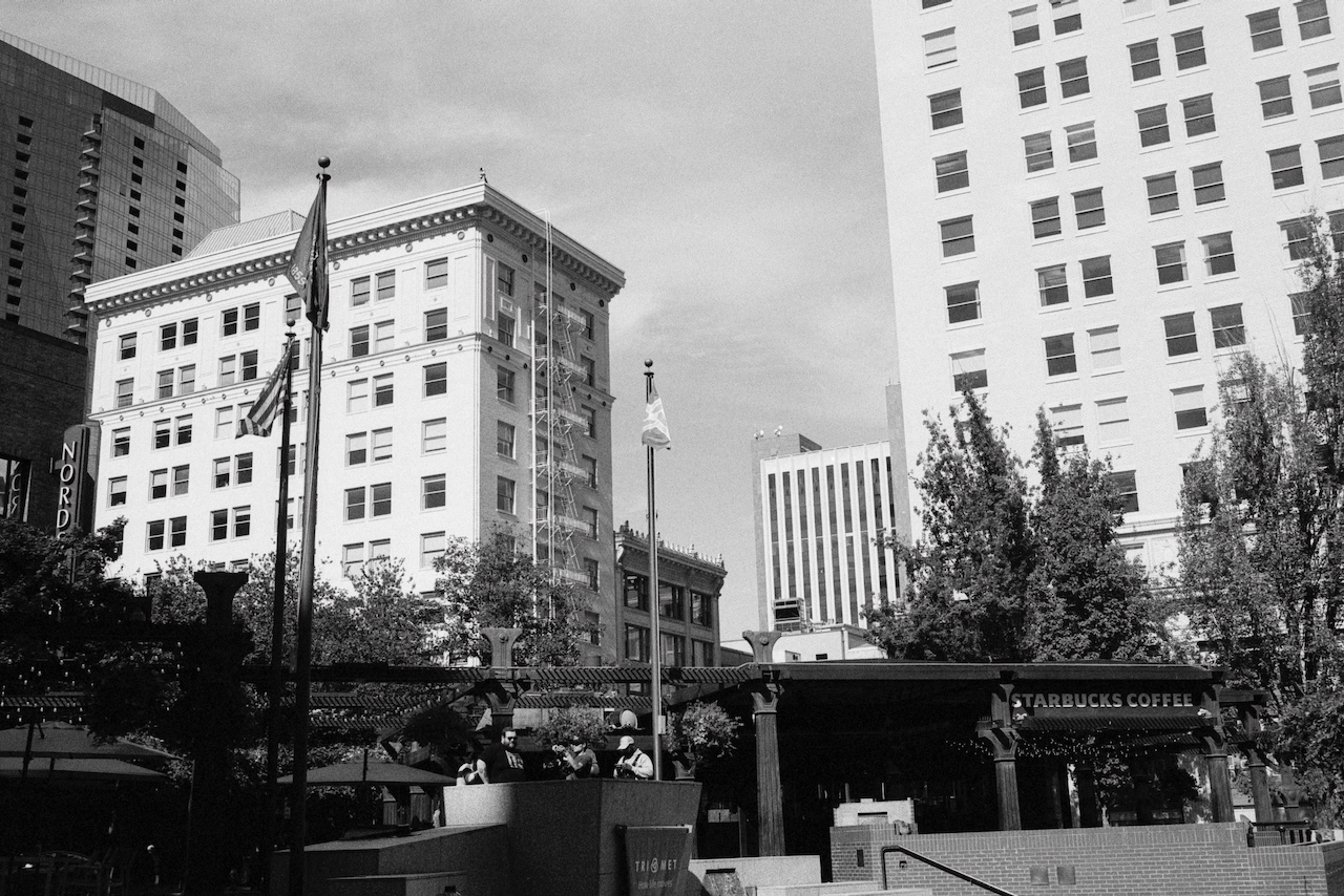 Black-and-white photo of art deco buildings and flagpoles at Pioneer Square in Portland, Oregon.