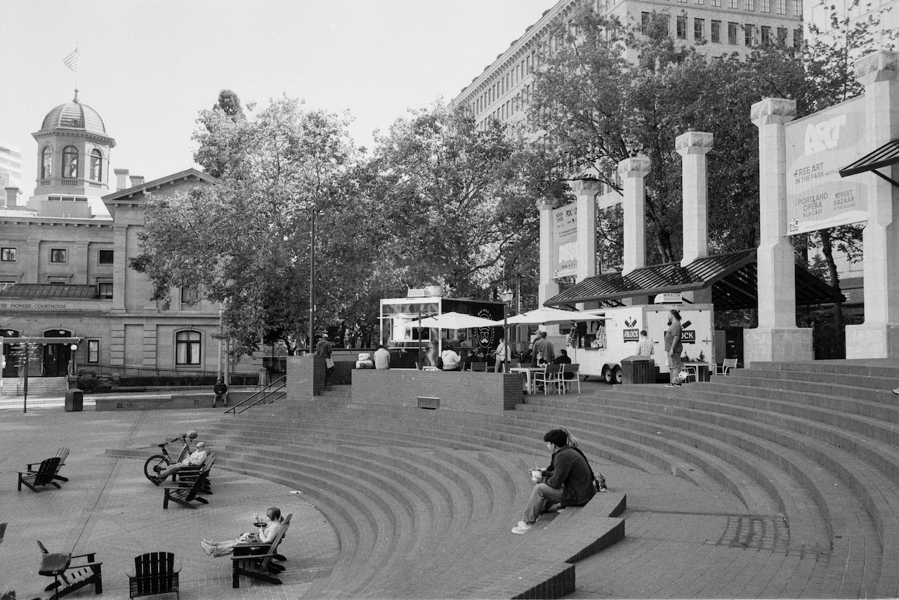 Black-and-white photo of people sitting on steps of Pioneer Square in Portland, Oregon.