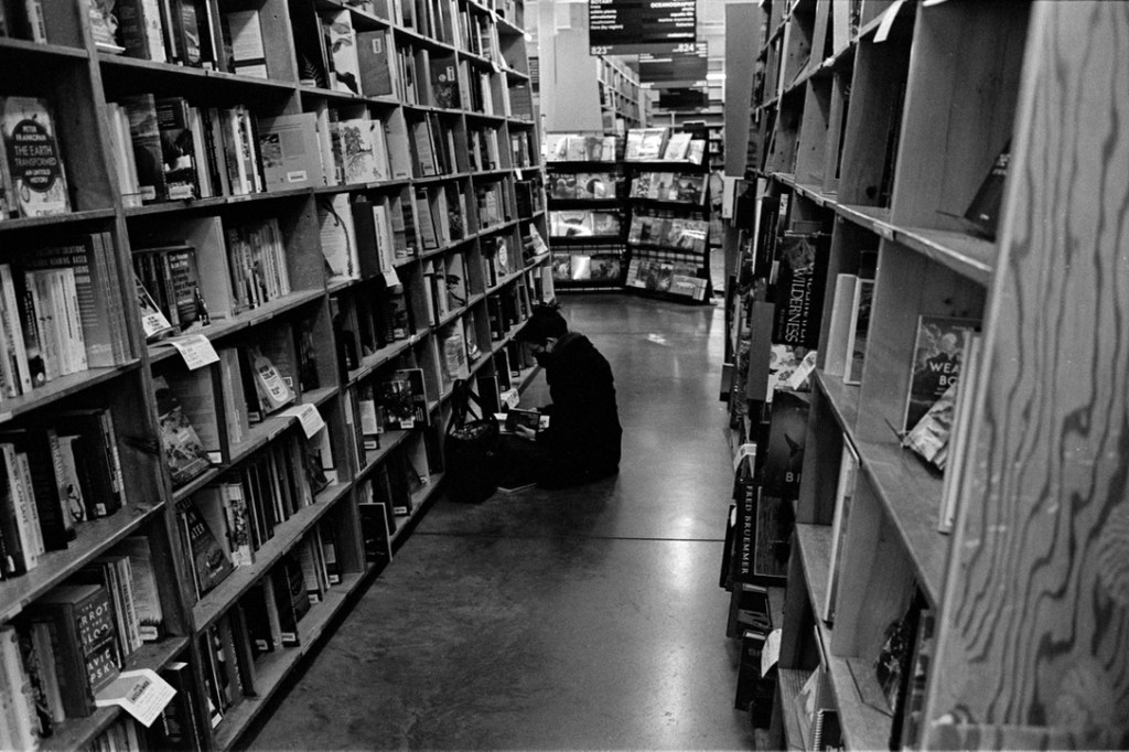 Women sitting on the floor reading in a book shop.